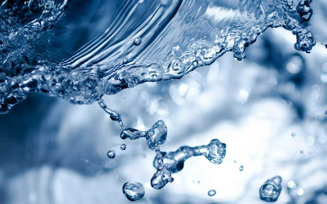 Close-up of pure water splashing, droplets suspended mid-air, symbolizing Clean Water Co.’s trusted Denver filtration solutions.
